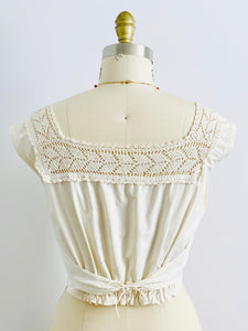 Back side of 1910s Edwardian White Crochet Lace top with pink high waisted pants on mannequin